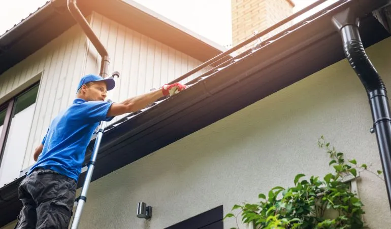Dan's Cleaning - Professional Gutter Cleaning Services in Perth and Melbourne. Man clearing debris from gutters.